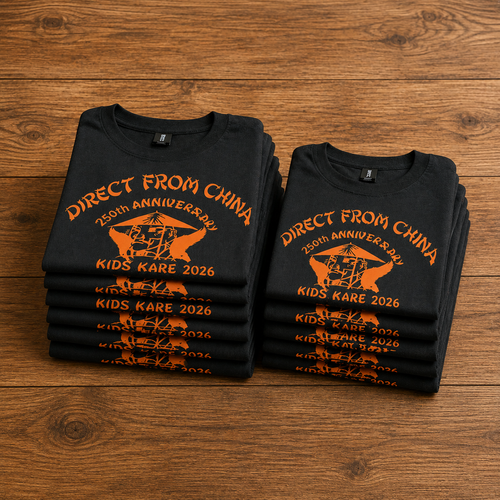 Two black t-shirts with orange text and graphics on a wooden surface